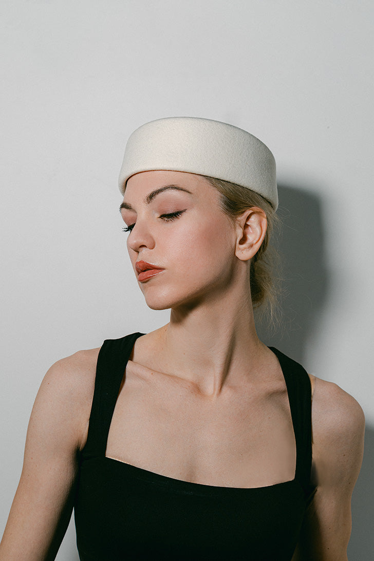 Woman wearing a white headband against a plain background